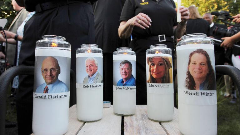 FILE - In this June 29, 2018, file photo, images of five employees of the Capital Gazette newspaper adorn candles during a vigil across the street from where they were slain in the newsroom in Annapolis, Md. Nearly three years after five people at the Capital Gazette newspaper were killed, a Maryland judge discussed plans Tuesday, April 13, 2021, for holding the second part of the shooter&#39;s trial under COVID-19 court protocols. (AP Photo/Jose Luis Magana, File)