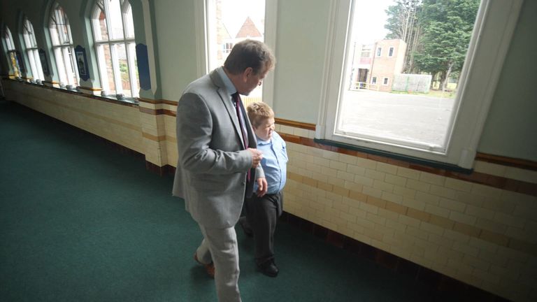 St Vincent&#39;s headteacher Dr John Patterson walks with one of his students.