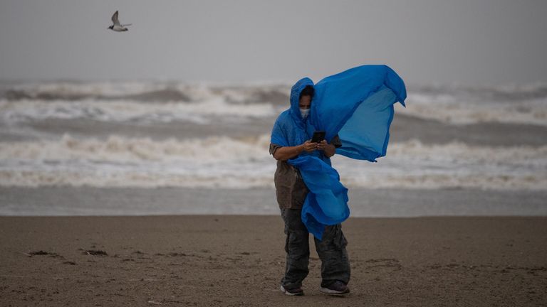 A  bird flies past local resident America Milligan as she tries to take photos in high winds and rain ahead of the arrival of Tropical Storm Nicholas in Galveston, Texas