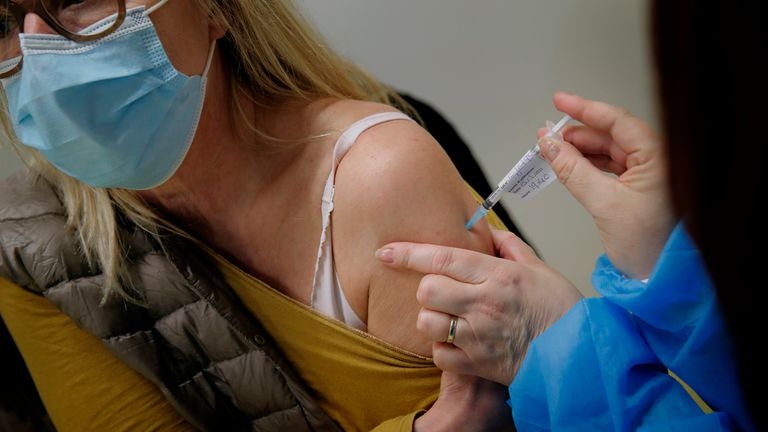 An Health care worker receives a Pfizer-BionTech COVID-19 vaccine at a coronavirus vaccine center in Poissy, France  (AP Photo/Christophe Ena)
