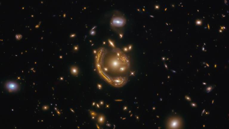 Gravitasi gugus bintang yang sejajar sempurna antara Hubble dan galaksi di kejauhan mengubah cahaya menjadi lensa.  Gambar: Saurabh Jha