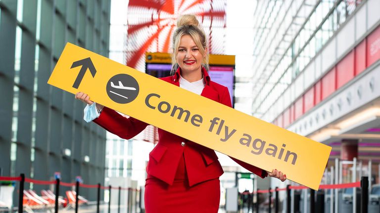 Virgin Atlantic cabin crew, Nicole Davis unveils new ???COME FLY AGAIN??? signage at London???s Heathrow Airport to celebrate the safe reopening of international travel and mark Heathrow&#39;s 75th anniversary