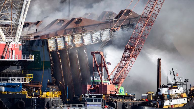 Fire fighters spray water into the cut away mid-section of the cargo vessel Golden Ray, Friday, May 14, 2021, Brunswick, Ga. The Golden Ray had roughly 4,200 vehicles in its cargo decks when it capsized off St. Simons Island on Sept. 8, 2019. Crews have used a giant gantry crane to carve the ship into eight giant chunks, then carry each section away by barge. (AP Photo/Stephen B. Morton)

