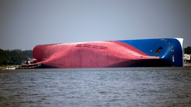 FILE - In this Sept. 9, 2019, file photo, a Moran tugboat nears the stern of the capsizing vessel Golden Ray near St. Simons Sound off the coast of Georgia. Demolition of the large cargo ship along the coast of Georgia is entering its fifth month, with work to chop the ship into eight large pieces going far slower than the salvage crew anticipated. (AP Photo/Stephen B. Morton, File)


