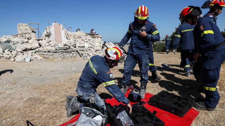 Firefighters check their gear next to the rubble of a demolished church, following an earthquake, in the town of Arkalochori on the island of Crete, Greece