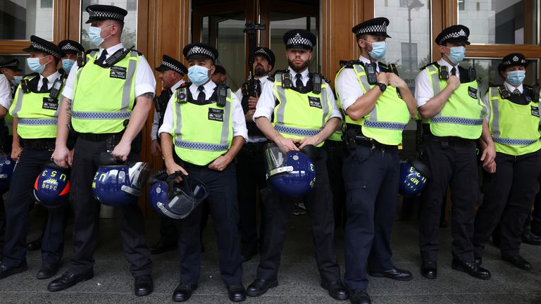 Police officers stand guard as members of the Official Voice group protest at Canary Wharf in London, Britain, September 3, 2021. REUTERS/Tom Nicholson