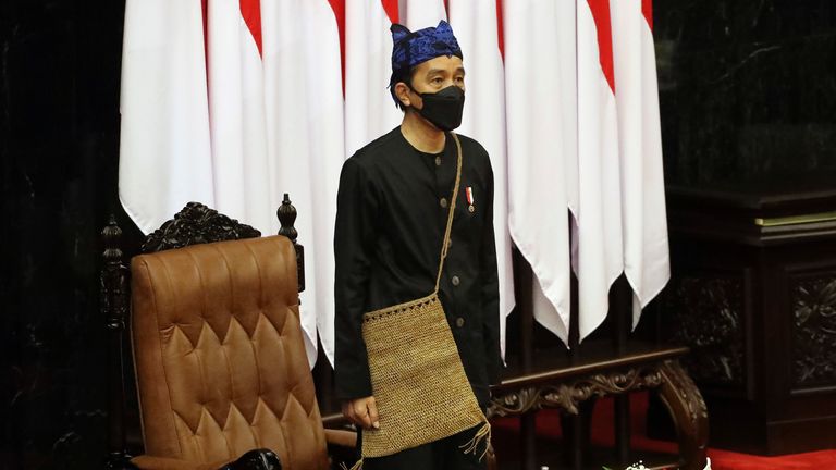 Indonesian President Joko Widodo listens to the national anthem after delivering his annual State of the Nation Address ahead of the country...s Independence Day, at the parliament building in Jakarta, Indonesia, Monday, Aug. 16, 2021. (Bagus Indahono, Pool photo via AP)