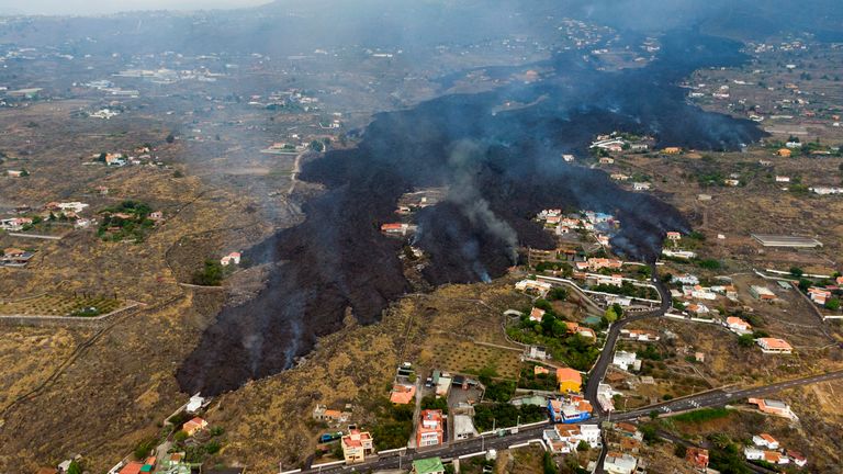 La lave d'une éruption volcanique coule détruisant des maisons sur l'île de La Palma aux Canaries, en Espagne, le mardi 21 septembre 2021. Un volcan endormi sur une petite île espagnole dans l'océan Atlantique est entré en éruption dimanche, forçant l'évacuation de milliers de personnes.  D'énormes panaches de fumée noire et blanche ont jailli d'une crête volcanique où les scientifiques surveillaient l'accumulation de lave en fusion sous la surface PIC:AP
