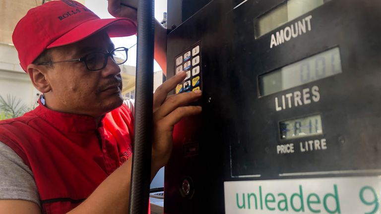 A gas station worker tries to set the new gasoline price after the latest increase in fuel prices, with most meters unable to accommodate the new five digit price for one liter of gas, in Beirut, Lebanon, Wednesday, Sept. 22, 2021. 