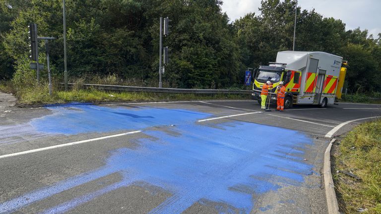 Les travailleurs de Highways England sur la bretelle de sortie de l'autoroute M25 près de Leatherhead après que des manifestants aient bloqué la route et laissé de la peinture dessus.  Photo date : vendredi 17 septembre 2021.