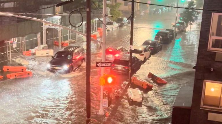 A vehicle moves along a flooded road in Williamsburg, in the Brooklyn borough of New York City