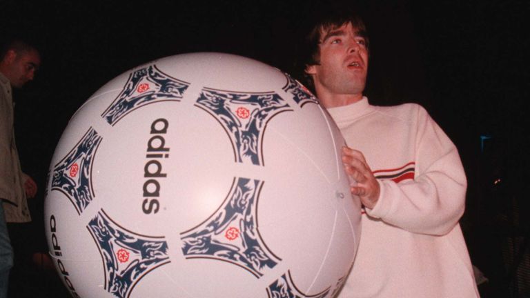 Noel Gallagher d'Oasis lance un ballon de football géant dans le public lors de leur concert à Knebworth Park dans le Hertfordshire en août 1996