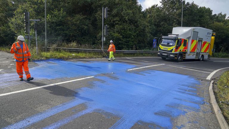 Highways England workers on the exit slip road of the M25 motorway near Leatherhead after protestors blocked the road and left paint on it. Picture date: Friday September 17, 2021.