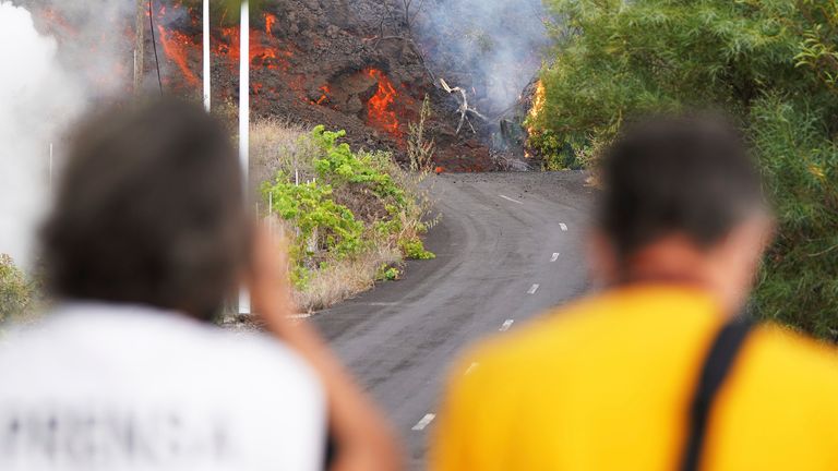 Two people watch on as lava advance through the area of Cabeza de Vaca