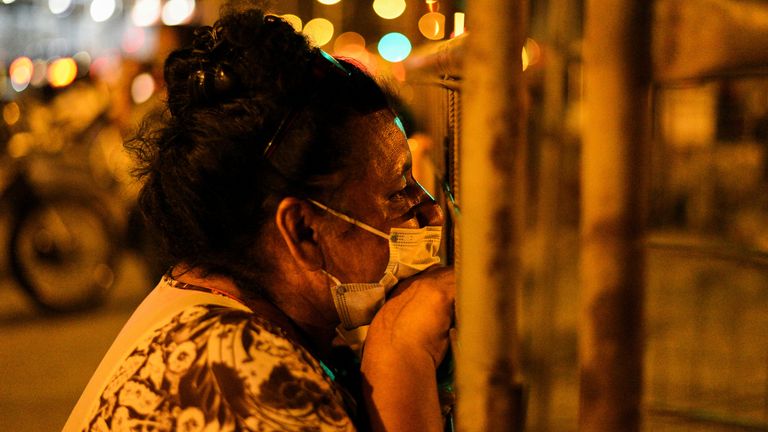 A woman waits outside of the prison waiting for news