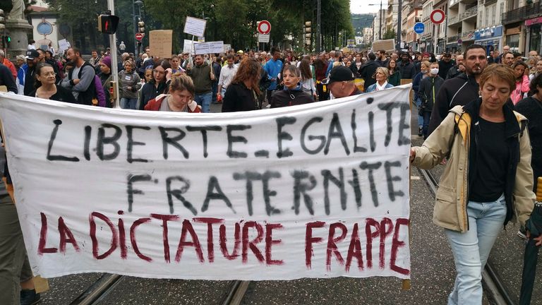 Demonstrators hold up banners during protests in Saint-Etienne against the mandatory COVID-19 vaccination for certain workers. Pic: AP