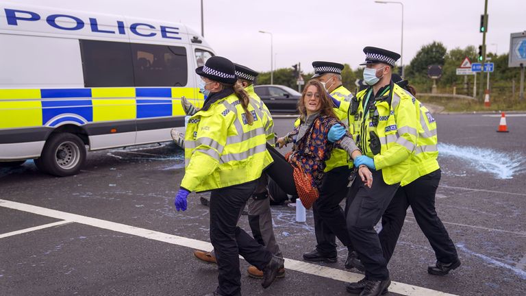 Police officers carry away a protester who had glued herself to a slip road at Junction 4 of the A1(M), near Hatfield, where climate activists carried out a further action after demonstrations which took place last week across junctions in Kent, Essex, Hertfordshire and Surrey. Picture date: Monday September 20, 2021.