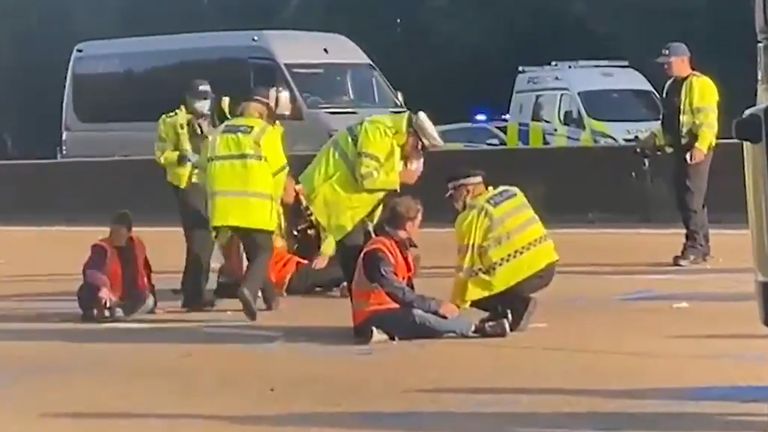mage courtesy of LBC showing police officers removing Insulate Britain activists from the M25 between junctions 9 and10 where the climate protesters carried out a further action after demonstrations which took place last week across junctions in Kent, Essex, Hertfordshire and Surrey. Picture date: Tuesday September 21, 2021.
