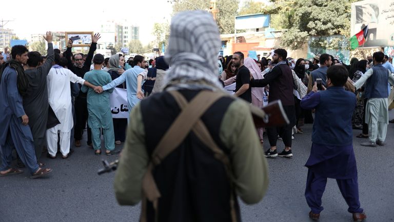 A Taliban soldier stands in front of protesters during the anti-Pakistan protest in Kabul, Afghanistan