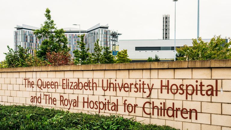 Glasgow, Scotland - A sign at the entrance to the Queen Elizabeth Hospital in Govan, Glasgow, with the main hospital building in the distance.