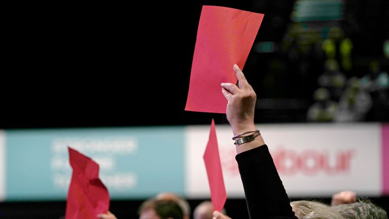 Delegates hold up a red cards as a group of hecklers attempt to interrupt the keynote speech of leader of the British Labour Party Keir Starmer at the annual party conference in Brighton, England, Wednesday, Sept. 29, 2021. (AP Photo/Alastair Grant)