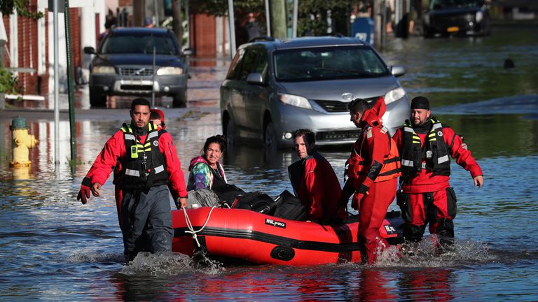 First responders pull residents in a boat following flooding in Mamaroneck, New York
