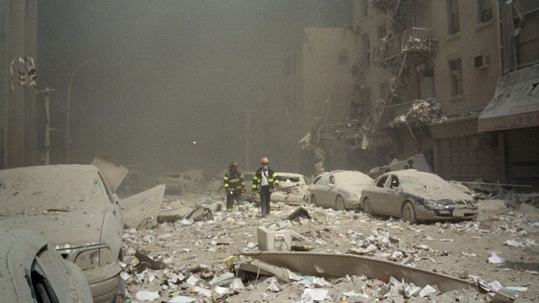 FIremen walk through a dust and debris covered street in lower Manhattan Tuesday, Sept. 11, 2001, after a terrorist attack at the World Trade Center. Two jet planes were crashed into the twin towers, collapsing them and covering the area with the debris.(AP Photo/Richard Cohen)