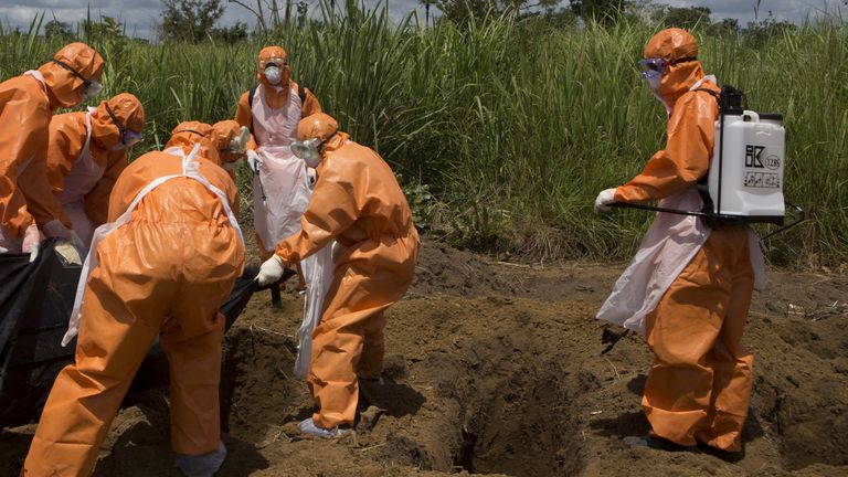 A burial team wearing protective clothes prepares an Ebola virus victim for interment, in Port Loko, Sierra Leone, September 27, 2014