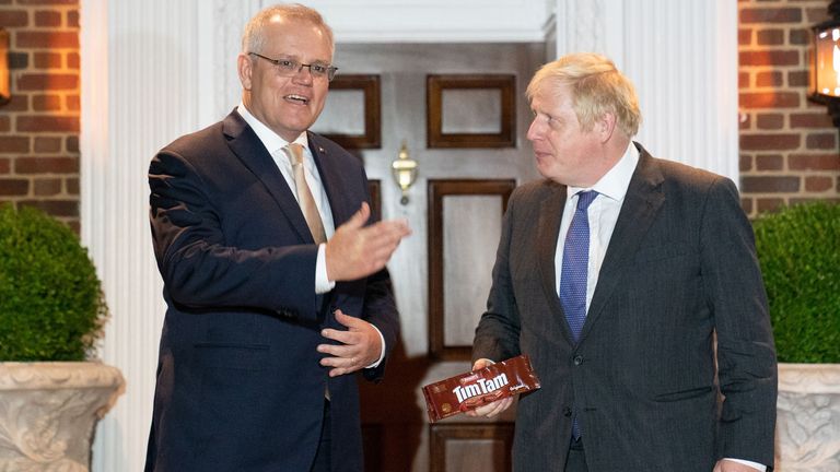 Prime Minister Boris Johnson is given a packet of the Australian snack, Tim Tams as he is greeted by his Australian counterpart, Scott Morrison in Washington DC, during his visit to the United States for the United Nations General Assembly. Picture date: Tuesday September 21, 2021.