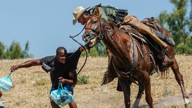  United States Border Patrol agent on horseback tries to stop a Haitian migrant from entering an encampment on the banks of the Rio Grande near the Acuna Del Rio International Bridge in Del Rio, Texas on September 19, 2021. - The United States said Saturday it would ramp up deportation flights for thousands of migrants who flooded into the Texas border city of Del Rio, as authorities scramble to alleviate a burgeoning crisis for President Joe Biden&#39;s administration