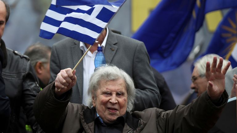 FILE - In this Sunday, Feb. 4, 2018 file photo, famous Greek composer Mikis Theodorakis waves a Greek flag after his speech at a rally in Athens, Greece. Mikis Theodorakis, the beloved Greek composer whose rousing music and life of political defiance won acclaim abroad and inspired millions at home, died on Thursday, Sept. 2, 2021. He was 96. (AP Photo/Petros Giannakouris, File)                                                 