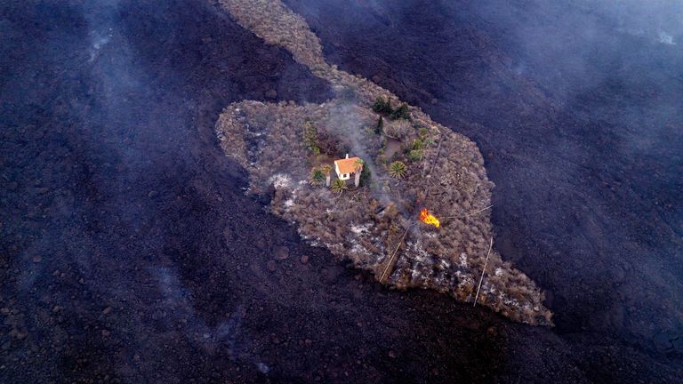 A house remains intact as lava flows after a volcano erupted near Las Manchas on the island of La Palma 
PIC:AP