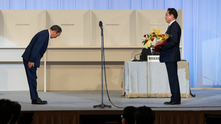 Japan’s outgoing Prime Minister, Yoshihide Suga, bows to former Fumio Kishida after the election result is announced