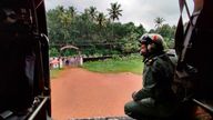 A navy airman looks out at Koottickal in Kottayam district, southern Kerala while on a mission to distribute relief material to flood affected people. Pic: AP