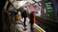 A woman wearing a face mask and holding a cup looks on at the Vauxhall tube station amid the coronavirus disease (COVID-19) outbreak