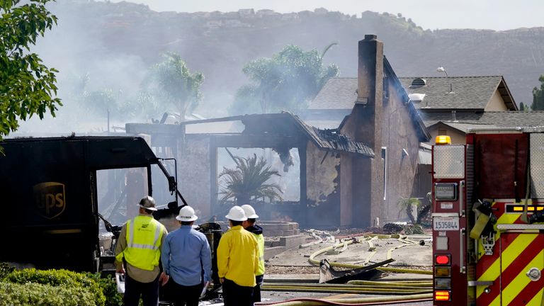 Fire and safety crews work the scene of a plane crash, Monday, Oct. 11, 2021, in Santee, Calif. At least two people were killed and two others were injured when the small plane crashed into a suburban Southern California neighborhood, setting two homes ablaze, authorities said. (AP Photo/Gregory Bull)