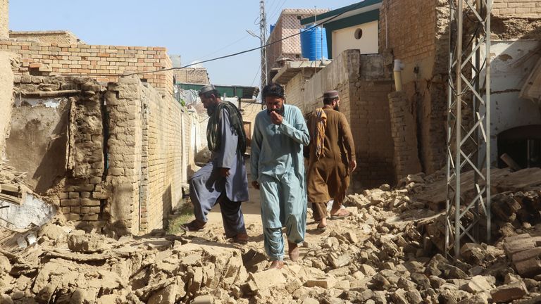 Residents walk amid the rubble of damaged houses along a street following an earthquake in Harnai, Balochistan, Pakistan, October 7, 2021. REUTERS/Naseer Ahmed
