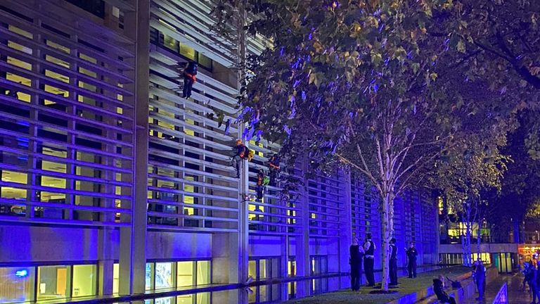 Les manifestants utilisaient des cordes et des mousquetons pour grimper dans le bâtiment sous le regard de la police.  Photo : Matt Grant