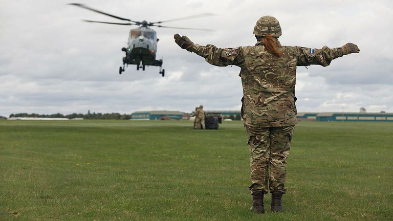 Pictured is a female Air Trooper, part of HQ Sqn, 6 AAC marshaling a Wildcat Helicopter onto a netted load. 
PIC: © Crown copyright