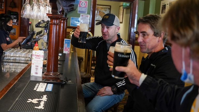 (L-R) Customers Brian O'Mara, Darrell Forman and Doug Thomas drink beers together at the Fortune of War pub, on the first morning of pubs and many other businesses re-opening to vaccinated people, following months of lockdown orders to curb an outbreak of the coronavirus disease (COVID-19), in Sydney, Australia, October 11, 2021. REUTERS/Loren Elliott