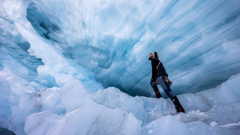 Glaciologist Martin Stocker-Waldhuber, from the Austrian Academy of Sciences, explores a natural glacier cavity of the Jamtalferner glacier near Galtuer, Austria, October 15, 2021. Giant ice caves have appeared in glaciers accelerating the melting process faster than expected as warmer air rushes through the ice mass until it collapses. Picture taken October 15, 2021. REUTERS/Lisi Niesner
