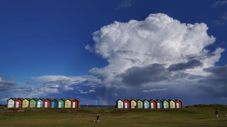 A rainbow appears behind the Blyth beach huts in Northumberland