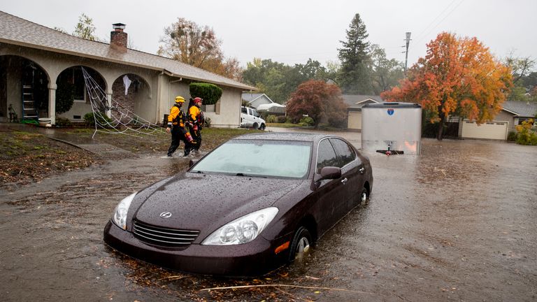 Santa Rosa firefighters check for residents trapped by floodwaters on Brookhaven Drive in Santa Rosa, Calif., Sunday, Oct. 24, 2021. (AP Photo/Ethan Swope)