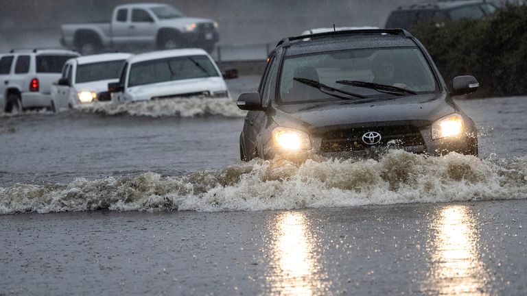 Vehicles drive through a flooded area as a powerful storm drenched northern California in Fairfield, California, U.S. October 24, 2021. REUTERS/Carlos Barria