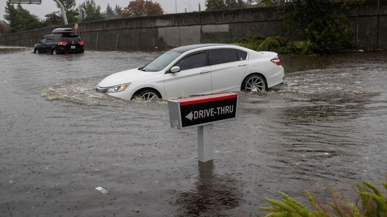A vehicle drives through a flooded area as a powerful storm drenched northern California in Fairfield, California, U.S. October 24, 2021. REUTERS/Carlos Barria TPX IMAGES OF THE DAY