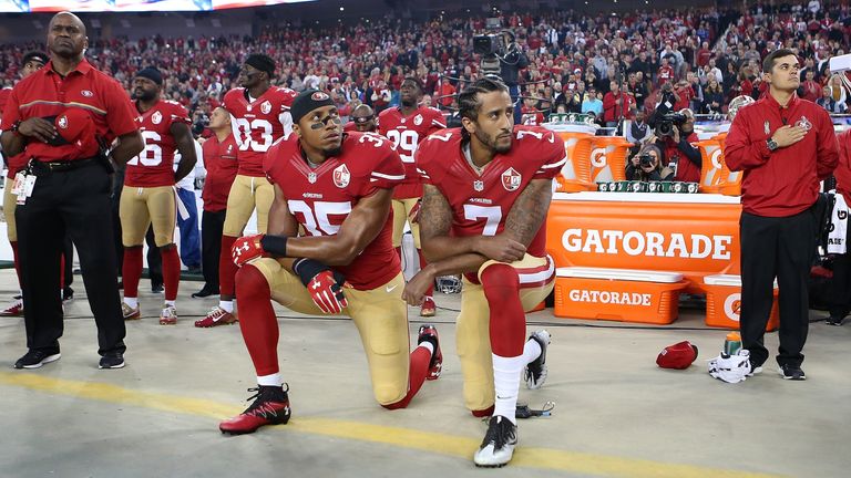 Los San Francisco 49ers Eric Reid (35) y Colin Kaepernick (7) se arrodillan durante el himno nacional en un partido de fútbol americano de la NFL en 2016