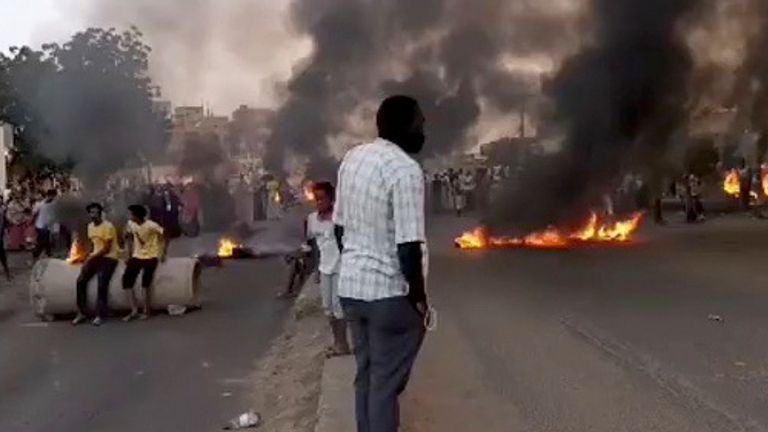 People gather as fire and smoke are seen on the streets of Kartoum, Sudan, amid reports of a coup, October 25, 2021, in this still image from video obtained via social media. RASD SUDAN NETWORK via REUTERS ATTENTION EDITORS - THIS IMAGE HAS BEEN SUPPLIED BY A THIRD PARTY. MANDATORY CREDIT. NO RESALES. NO ARCHIVES.
