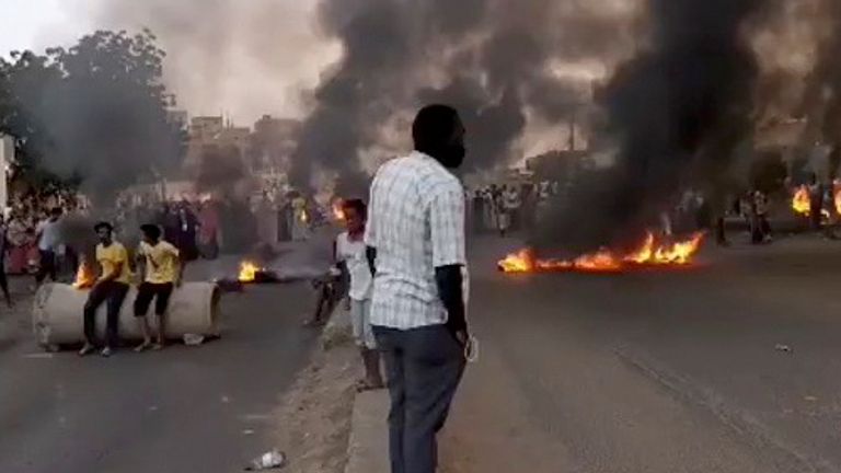 People gather as fire and smoke are seen on the streets of Kartoum, Sudan, amid reports of a coup, October 25, 2021, in this still image from video obtained via social media. RASD SUDAN NETWORK via REUTERS ATTENTION EDITORS - THIS IMAGE HAS BEEN SUPPLIED BY A THIRD PARTY. MANDATORY CREDIT. NO RESALES. NO ARCHIVES.
