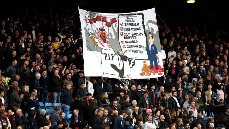 Crystal Palace fans with a banner about Newcastle United&#39;s takeover before the match