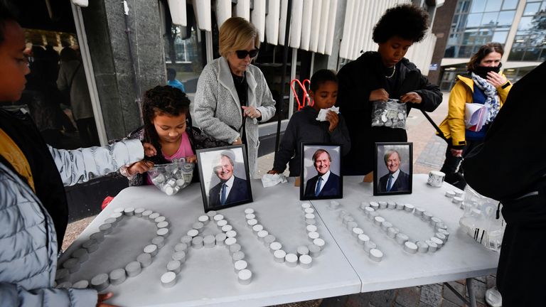People spell out Sir David&#39;s name with candles at a vigil